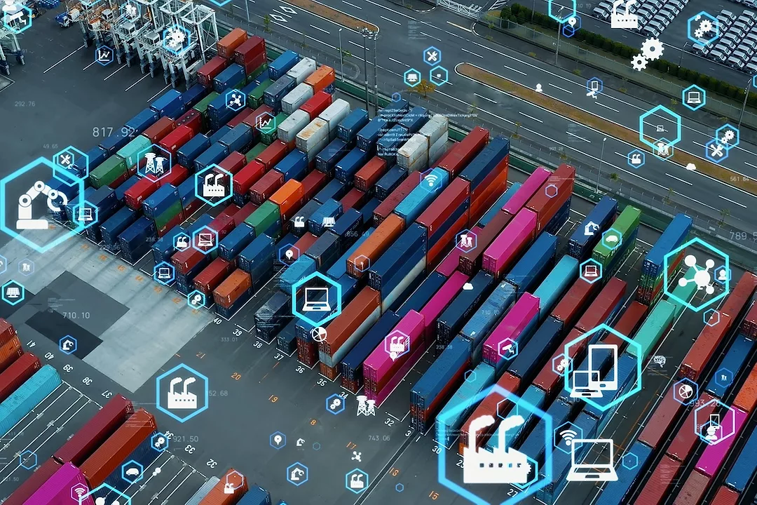 Stacks of multi-colored shipping containers in a concrete port yard, with blue hexagons depicting symbols overlayed over the top of the image