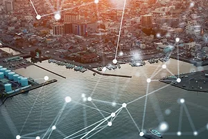 BRIGHT LINES OF LIGHT SUPER-IMPOSED OVER AN AERIAL SHOT OF A PORT INDICATE MOVEMENT OF DATA