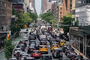 A WIDE CITY STREET IS CRAMMED WITH CAR TRAFFIC