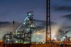 A STEEL MILL, RESPLENDENT WITH TOWERS AND PIPES, GLOWS IN THE NIGHT